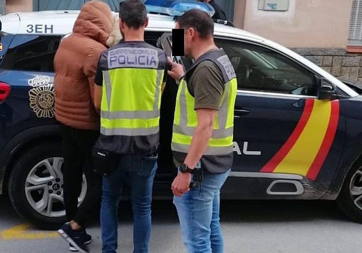 Dos policías detienen a uno de los acusados de arrancar 11 video-porteros en Lorca.