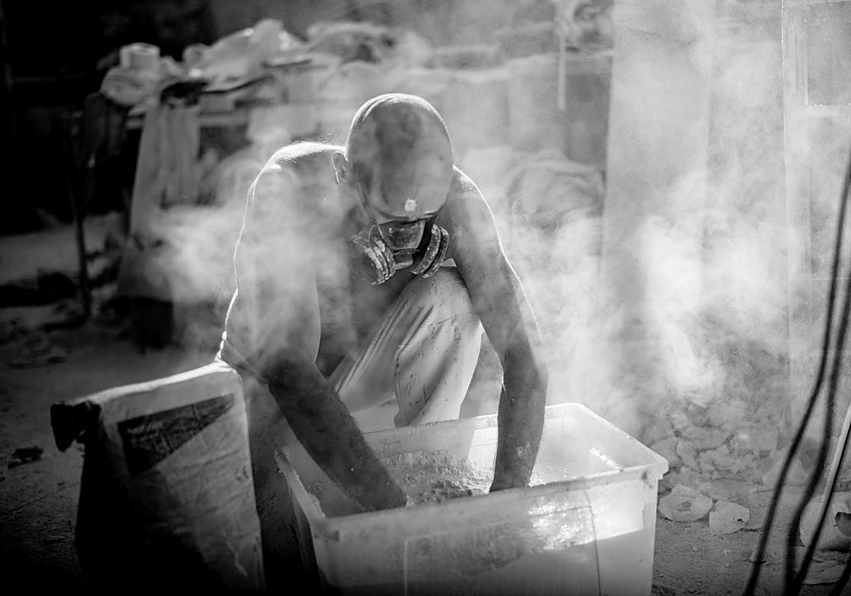 Imagen principal - Arriba, el creador, enmascarado, manipula material sensible. Abajo, un detalle de su brazo y en uno de los gestos congelados.