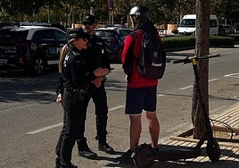 Dos agentes explican los detalles de la normativa a un vecino.