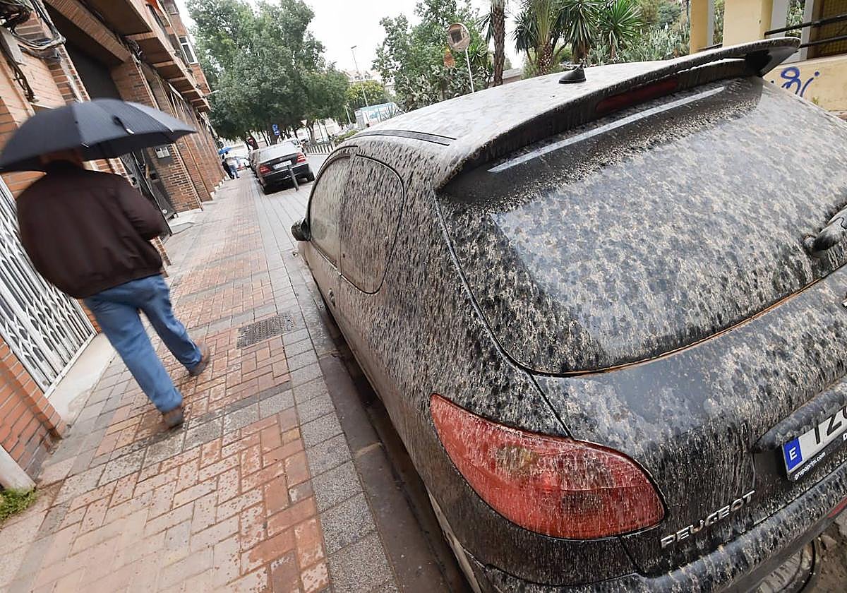Imagen de archivo de un coche afectado por lluvia de barro en una calle de Murcia.