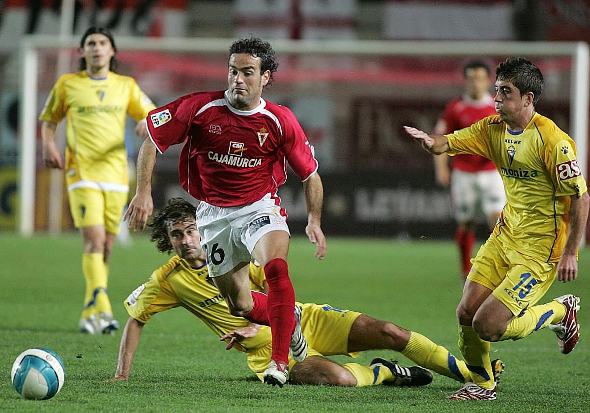 Paco Peña conduce el balón perseguido por Pablo Hernández y Fleurquin (en el suelo), en el Real Murcia-Cádiz de la temporada 2006-07.