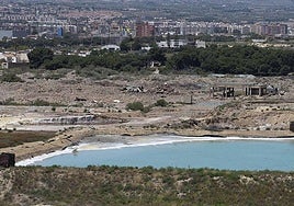 Una de las balsas de residuos peligrosos de Zinsa llena de agua; detrás, escombros de la demolida factoría Española del Zinc.