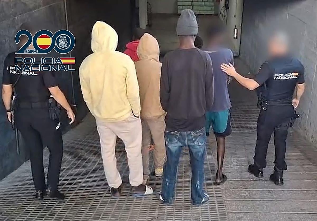 Dos agentes de la Policía Nacional junto con los detenidos.
