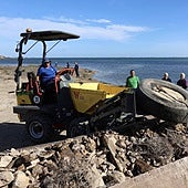 Un operario retira un neumático encontrado en el entorno de la rambla del Albujón, este sábado, durante la jornada de limpieza convocada por Hippocampus.