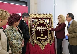 La bordadora Silvia Teruel explica los detalles del estandarte ante el presidente el concejal de Cultura, el presidente de la Federación San Clemente e integrantes de ésta.