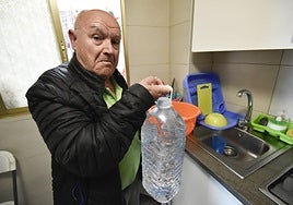 Jesús Peñaranda, con una garrafa de agua, ayer en su piso.