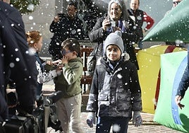 Eiden Moreno, al centro, rodeado de vecinos, durante la caída de nieve artificial en Torreagüera.
