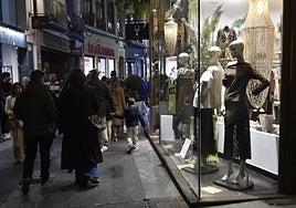 Viandantes pasan por los escaparates de los comercios de la calle Sociedad de Murcia.