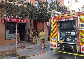 Bomberos en la entrada del local incendiado.
