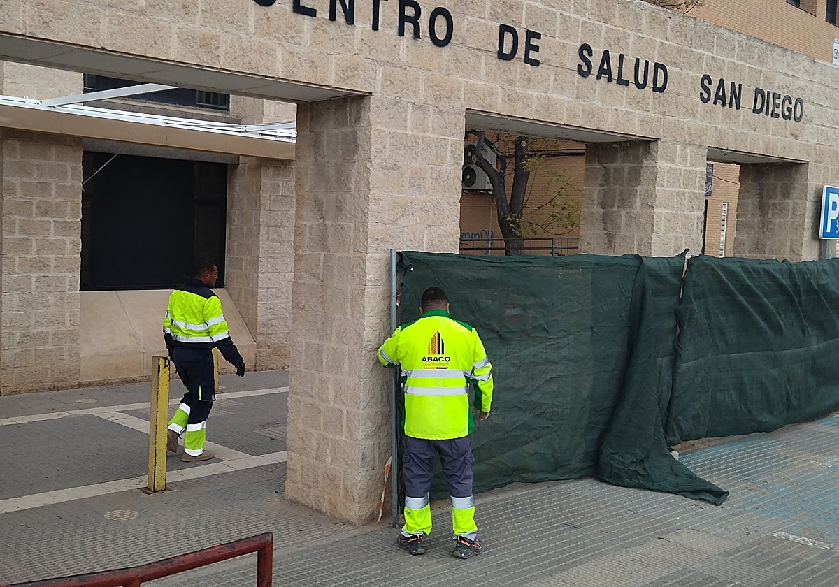 Operarios colocan las vallas para el inicio de las obras en el centro de salud de San Diego.