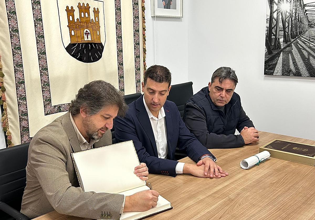 El músico Víctor Cano firma en el libro de honor del municipio.