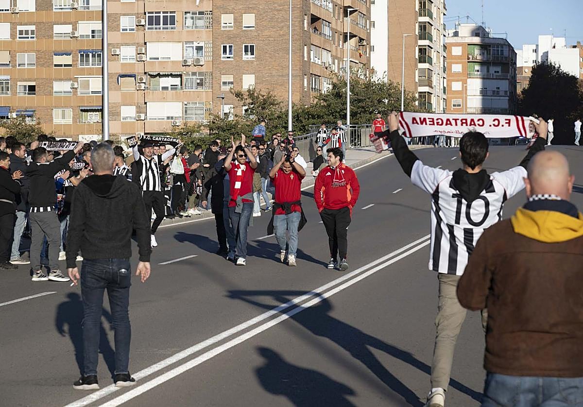 Tres seguidores del Murcia pasan por el puente de Soldado Rosique ante la mirada de varios cartageneristas.