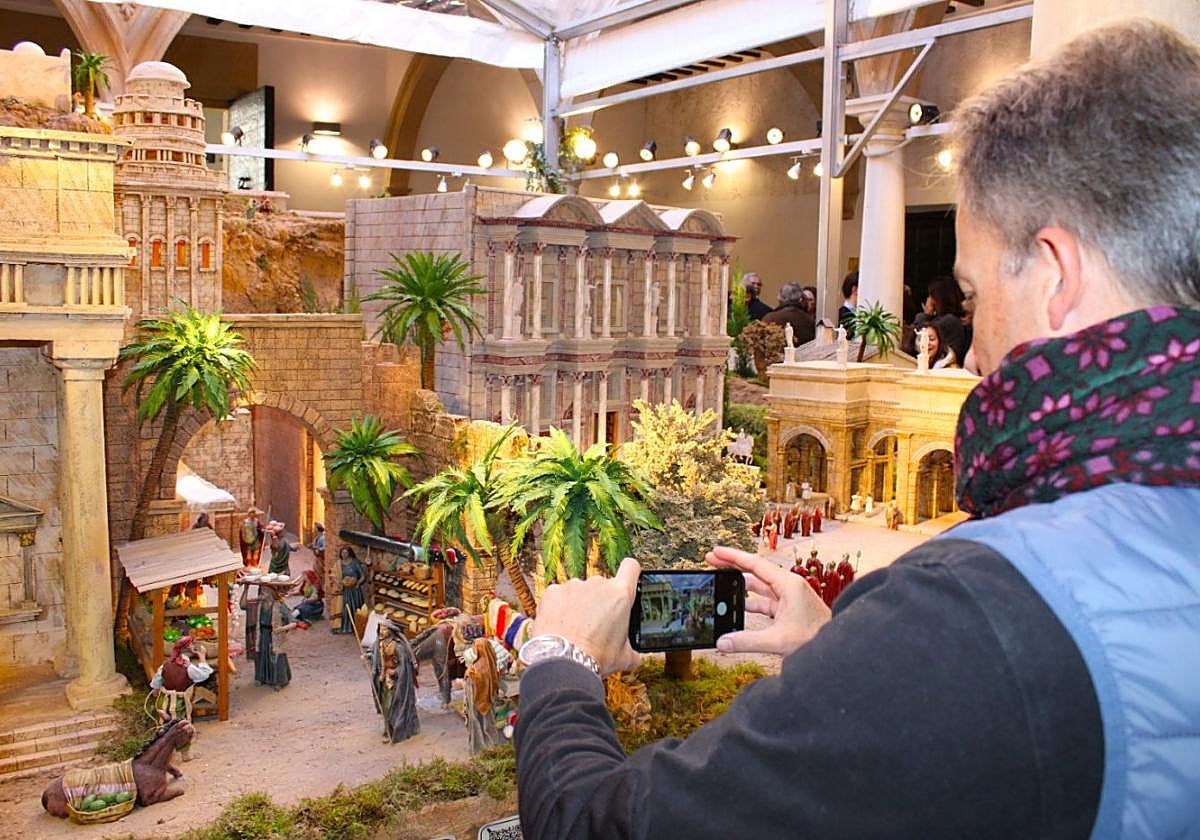 El alcalde fotografía con su móvil el belén en la inaguración, ayer.