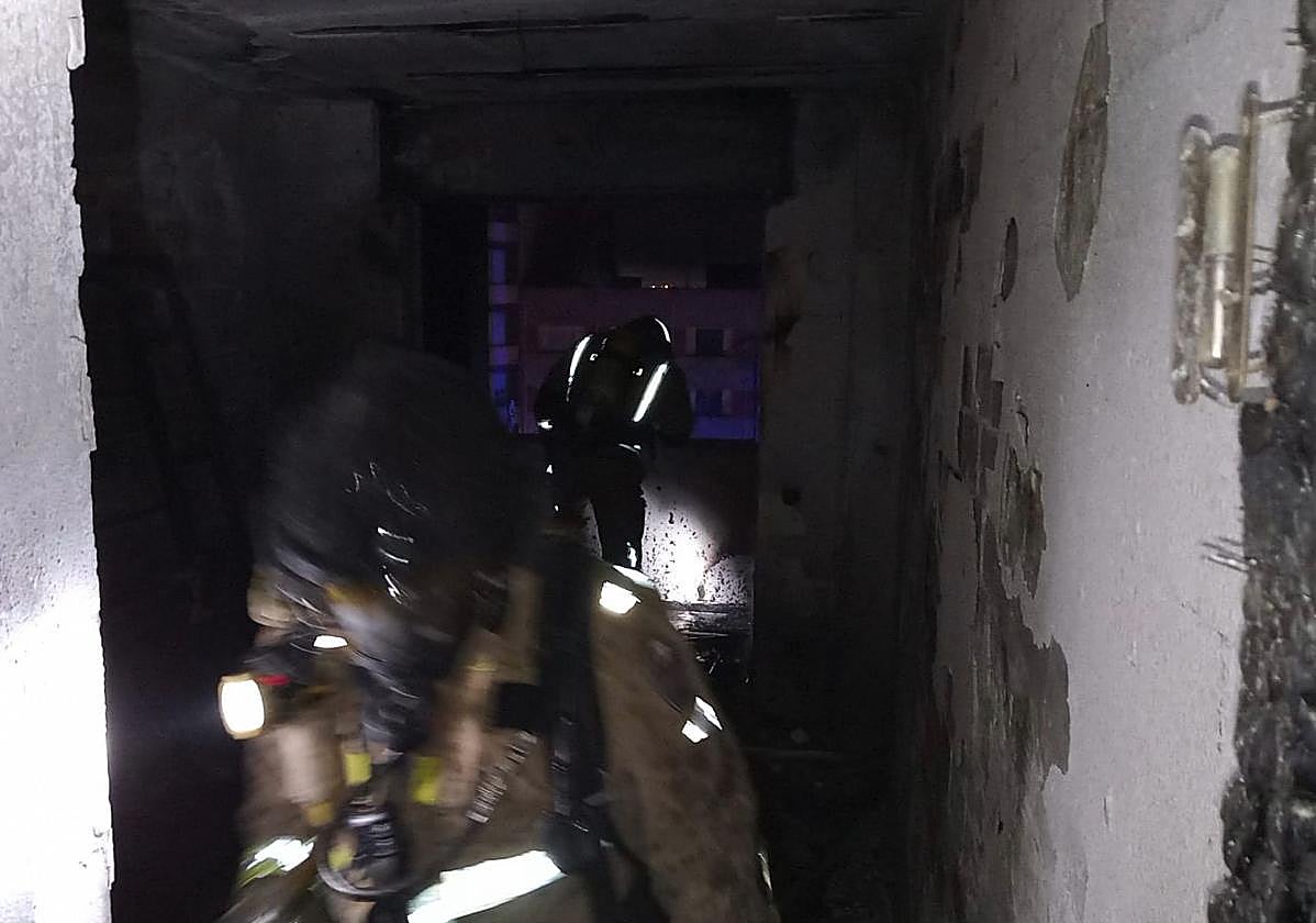 Bomberos entran en la vivienda afectada.