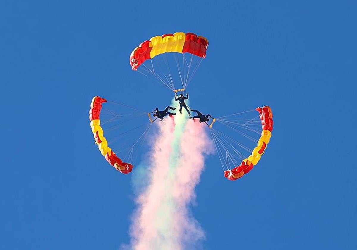 Tres paracaidistas de la Papea realizan una acrobacia durante la exhibición.