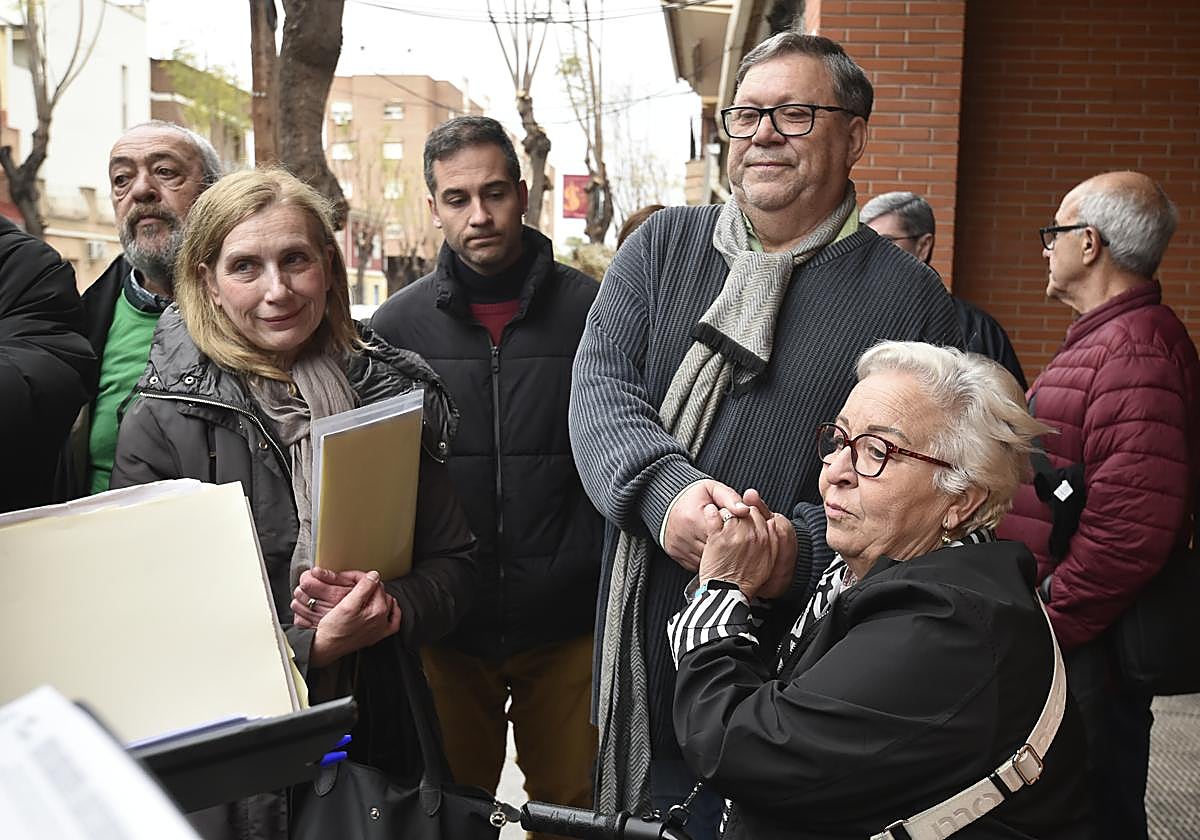 Antonia, la vecina afectada por en desahucio, toma la mano de Joaquín Sánchez, 'el cura de la PAH'.