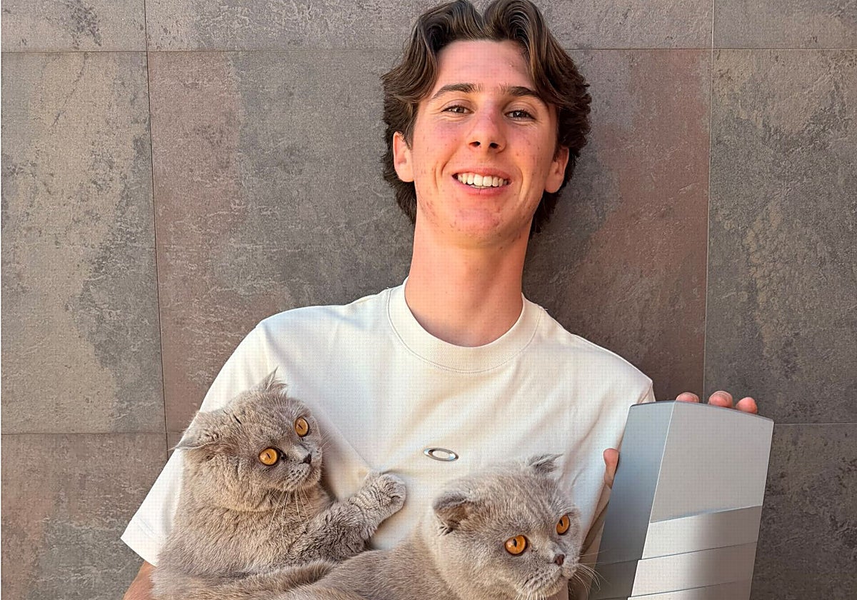 Máximo Quiles, en su casa, con sus gatos y el trofeo de campeón de Moto3.