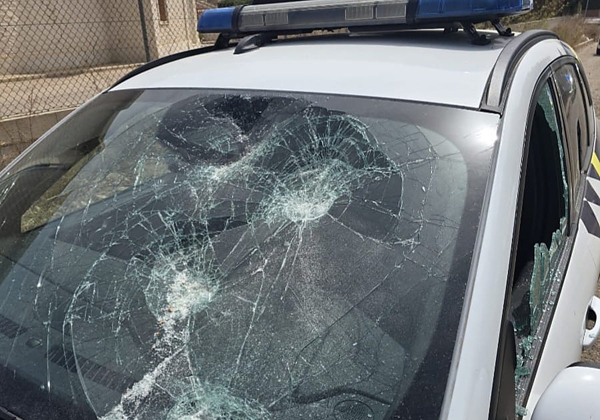 Luna delantera de un coche de la Policía Local destrozada por las pedradas.
