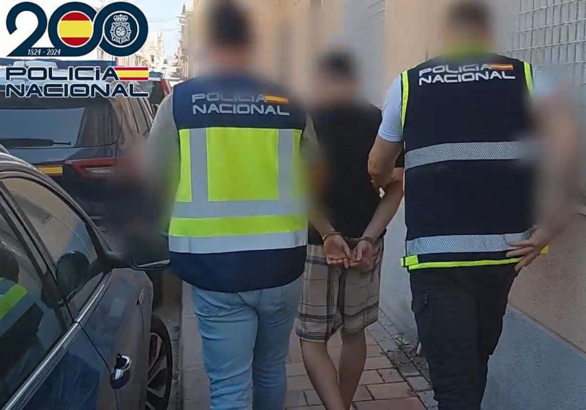 Dos agentes escoltan al detenido.