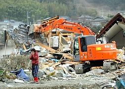 Una mujer llora al ver su nueva casa en ruinas tras el paso del tsunami. / Efe