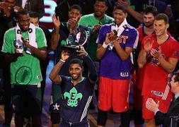 Kyrie Irving levanta su trofeo de 'MVP' ante compañeros y rivales. / Afp