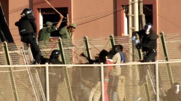 La policía marroquí hostiga a los seis inmigrantes que se encontraban encaramados a la valla de Melilla después de un nuevo intento de entrada a la ciudad autonóma