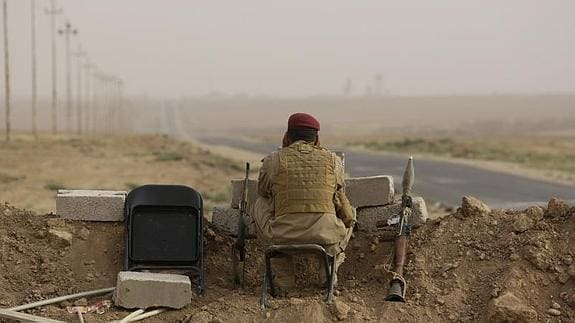 Un militar iraquí vigila una carretera al norte de Bagdad 