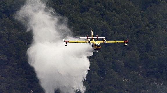 Un hidroavión participa en las labores de extinción de un incendio en Valencia. 