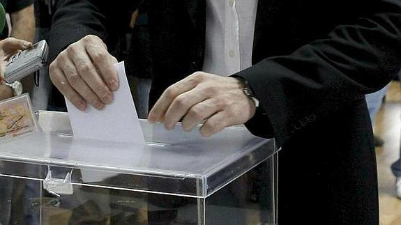 Un ciudadano depósita su voto en una urna. 