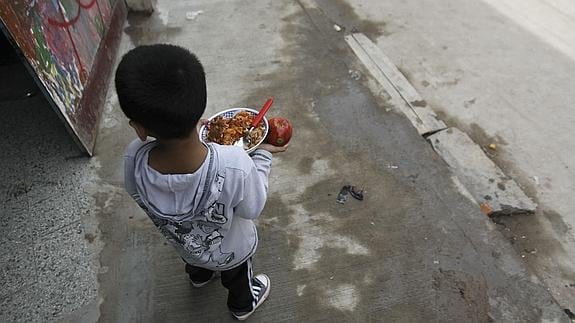 Un niño argentino, junto a un comedor solidario.