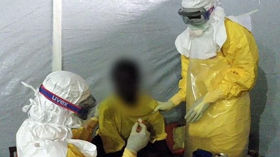Médicos y enfermeras con ropa protectora atendiendo a un hombre infectado con ébola 
