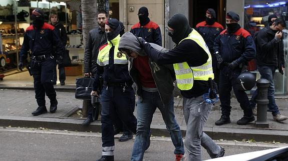 Los Mossos escoltan a uno de los detenidos. 