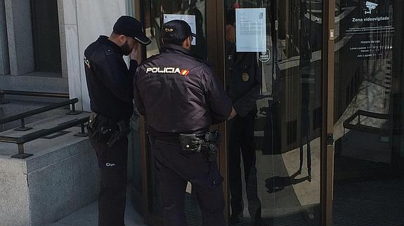 El guarda de seguridad intenta abrir la puerta a los policías.