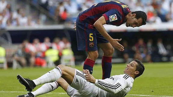 Sergio Busquets y Cristiano Ronaldo discuten en un partido. 