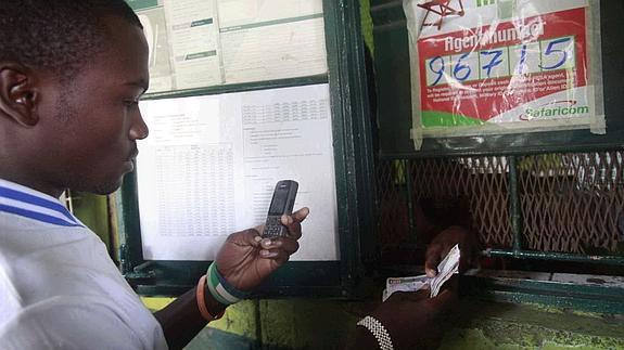 Un joven saca dinero en un servicio similar a los cajeros electrónicos en Nairobi, Kenia.