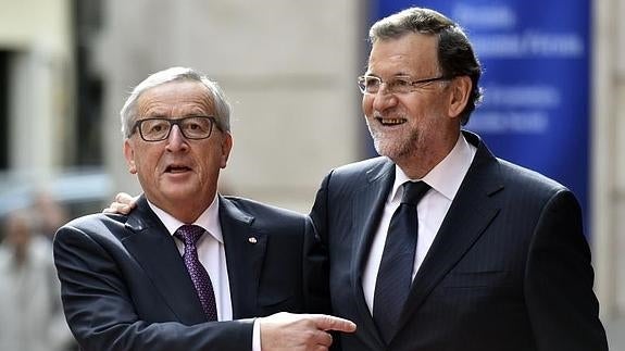 Rajoy (d.) saluda a Juncker a su llegada al Congreso. 