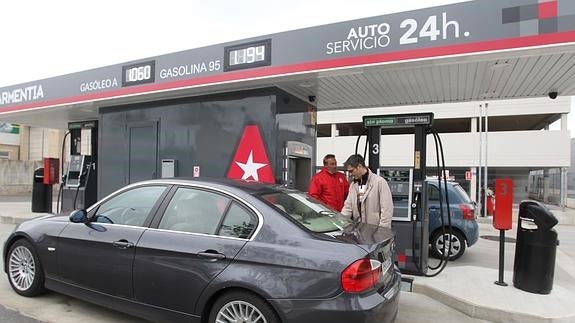 Personas repostando en una gasolinera. 