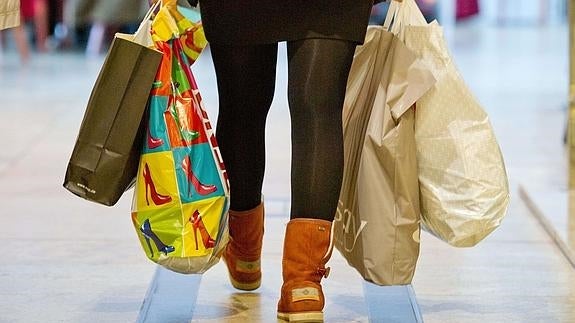 Una mujer con varias bolsas de compras. 