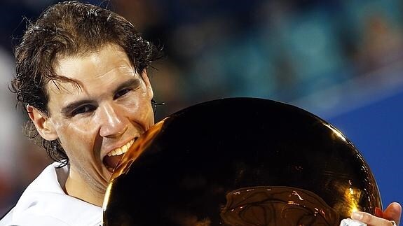 Nadal muerde el trofeo de campeón. 