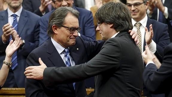 Carles Puigdemont y Artur Mas se dan un abrazo. 