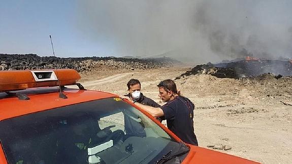 Dos efectivos de seguridad ante los restos del incendio.