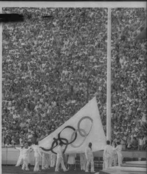 Voluntarios hizan la bandera de los Juegos Olímpicos de Los Angeles 1984. 