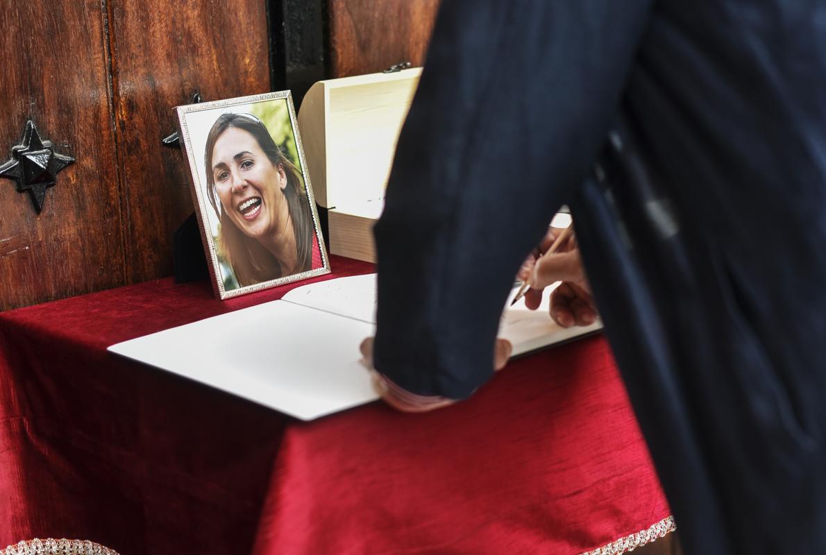 Un hombre firma en el libro de condolencias durante el funeral de María Villar. 
