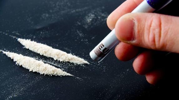 Un hombre se prepara para esnifar cocaína. 