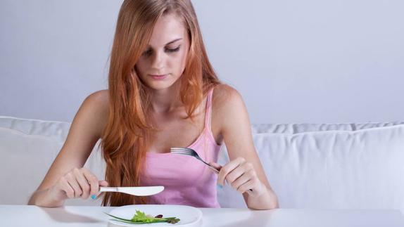 Restringir la ingesta de alimentos y comer compulsivamente son dos de los síntomas de la bulimia nerviosa.
