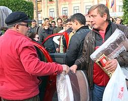 Un voluntario de la Asociación Abeto entrega dos mantas y turrón a Konstantin. ::                             EDU BOTELLA/AGM