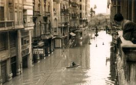 EN PIRAGUA. Aspecto de la emblemática calle valenciana de La Paz. Un vecino contempla una piragua en plena vía. / LAS PROVINCIAS