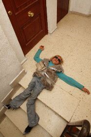 POR FIN EN CASA. María José se tiende, exhausta, cuando llega hasta la puerta de su hogar, después de subir arrastrándose las escaleras de su edificio/ MARTÍNEZ BUESO