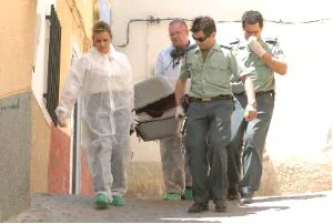 TRASLADO. Guardia Civil y funerarios sacan el cadáver de la vivienda. / GUILLERMO CARRIÓN / AGM