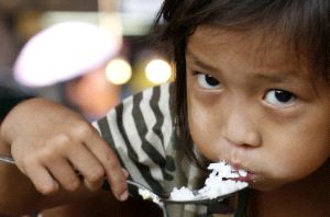 DESIGUALDAD. Una niña filipina come arroz, uno de los pocos alimentos a los que puede acceder. / REUTERS